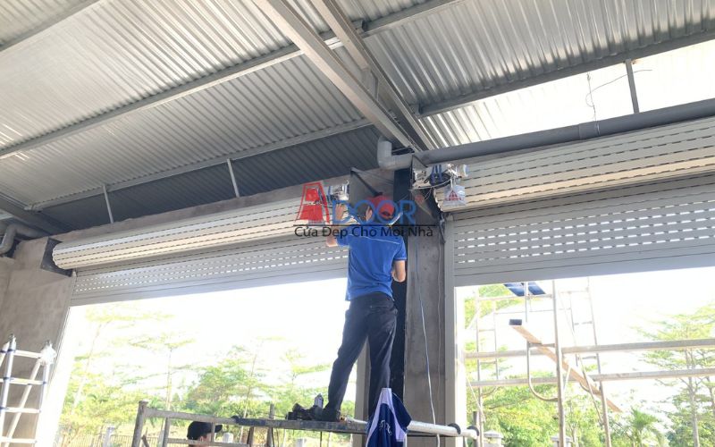 Kỹ thuật viên thi công cửa cuốn tại công trình nhà phố